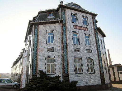 Eckansicht eines historischen Geb&auml;udes mit dekorativer Fassade, beschriftet mit &bdquo;Dr. Julius B&ouml;hme&ldquo;.
